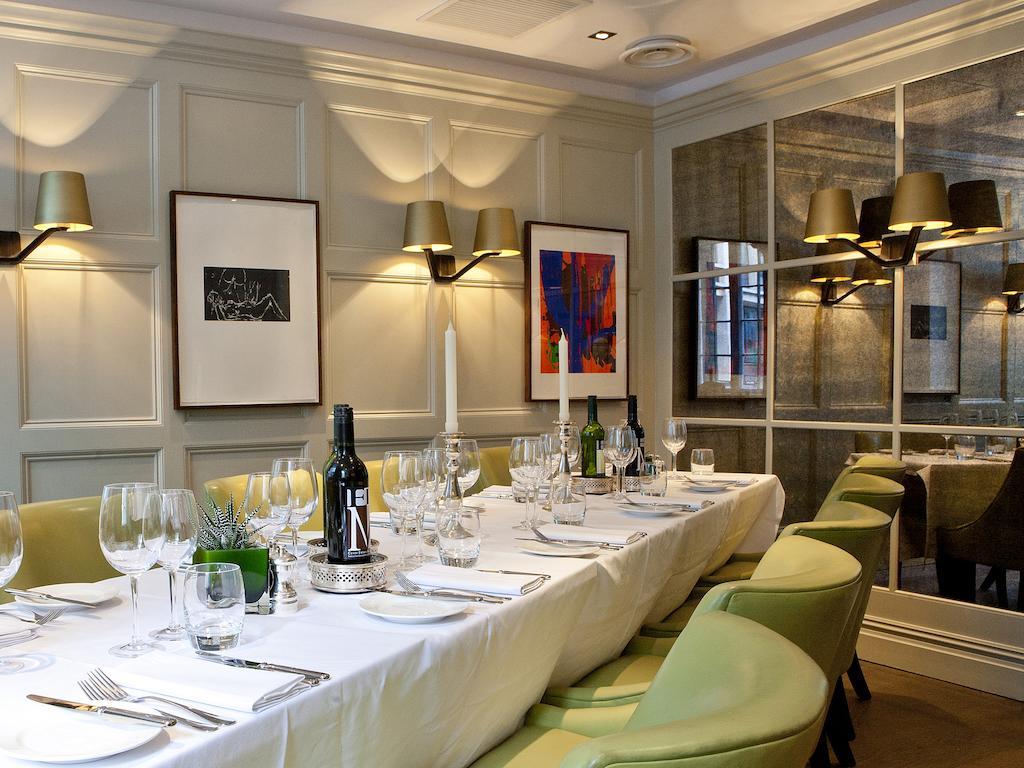 Hotel Montcalm Brewery Townhouse London Exterior foto The photo shows an elegant restaurant setting with a long dining table that is neatly set for a meal. The table is adorned with a white tablecloth, glassware, and silverware, indicating that it is prepared for a special gathering or event. 

Behind t