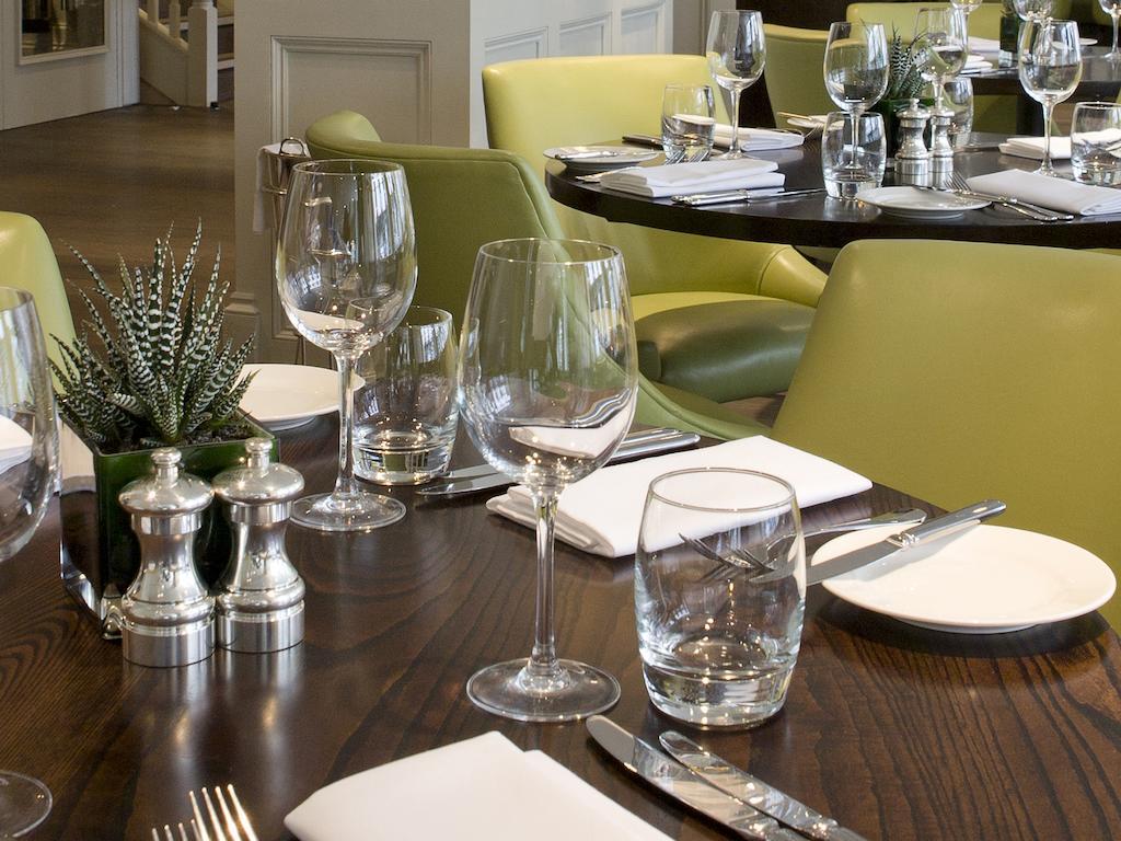 Hotel Montcalm Brewery Townhouse London Exterior foto The photo shows a dining setup in a restaurant. There are tables with a polished wooden surface and elegant place settings. Each setting includes multiple wine glasses and water glasses, neatly arranged with folded napkins. 

In the center, there are