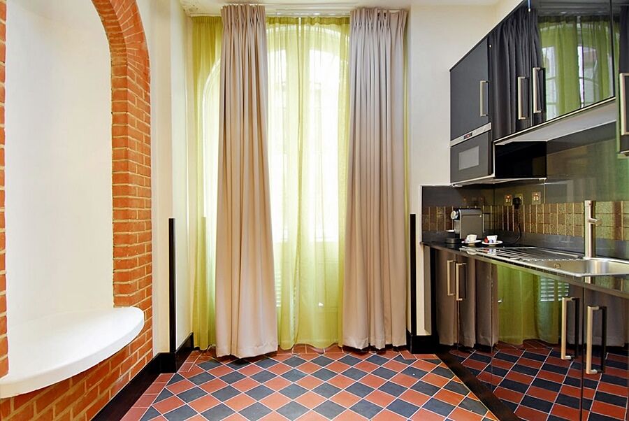 Hotel Montcalm Brewery Townhouse London Exterior foto The photo shows a kitchen area with modern design elements. There are large, light-colored curtains hanging from the windows, allowing natural light to filter in. The walls are partially exposed brick, giving a warm texture to the room. The flooring 
